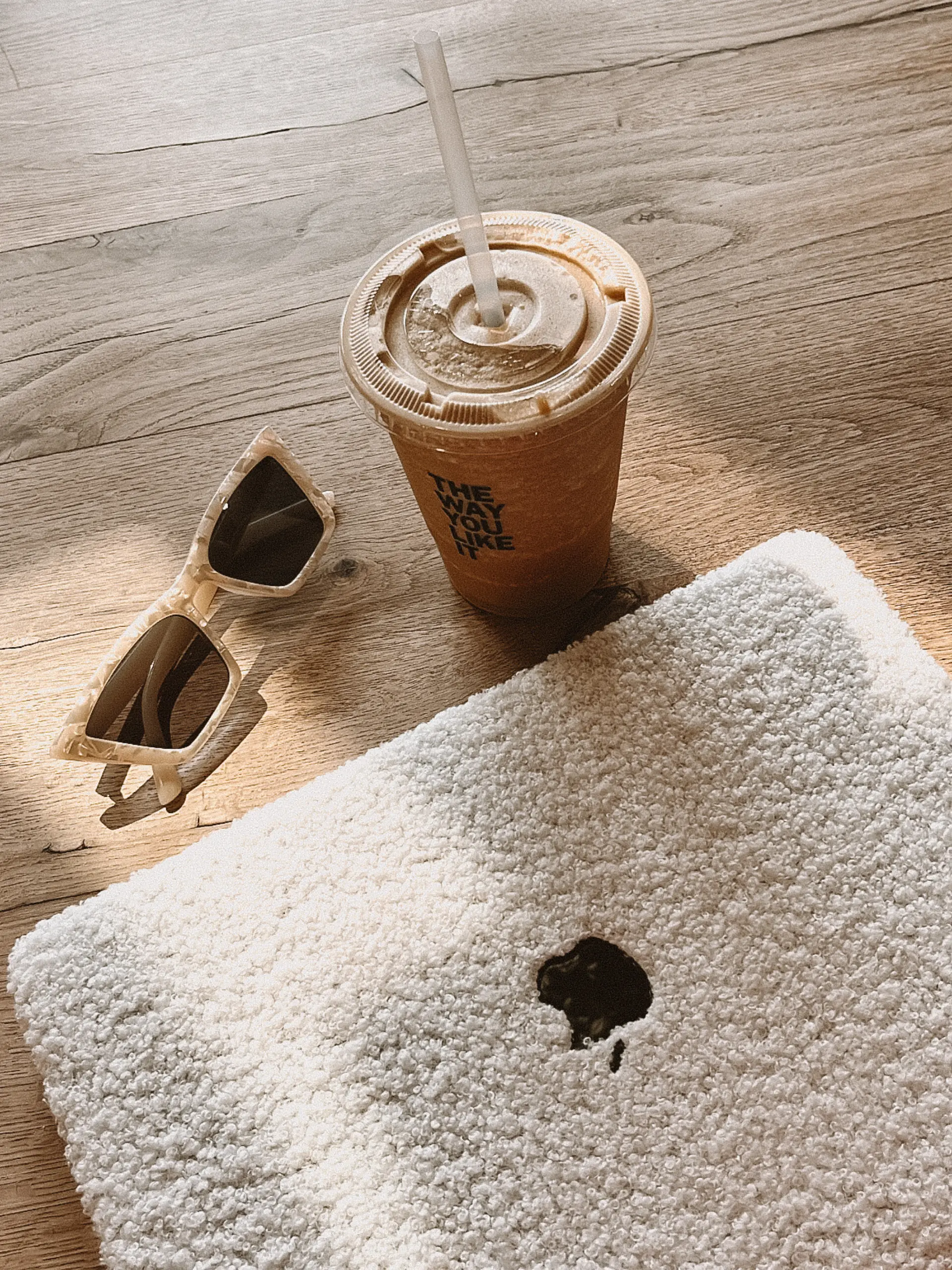 Espace de travail chill avec un café, un ordinateur et une paire de lunette de soleil.